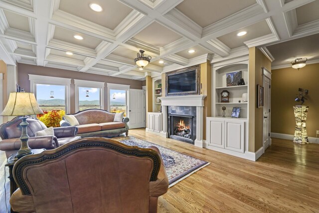 living room with coffered ceiling, beamed ceiling, built in shelves, crown molding, and hardwood / wood-style flooring