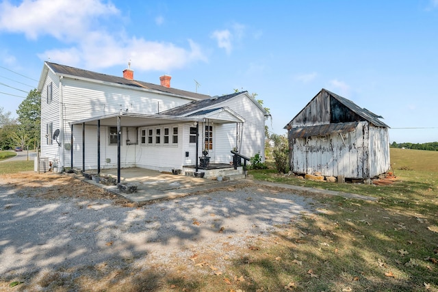 view of front of home featuring a storage shed and a porch