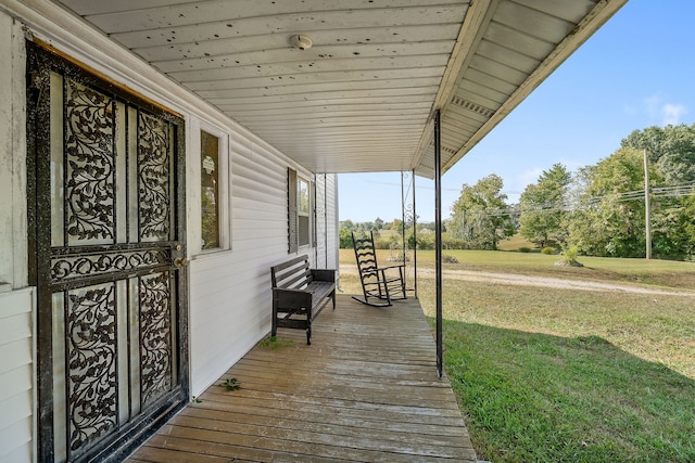 wooden terrace featuring a yard and a porch