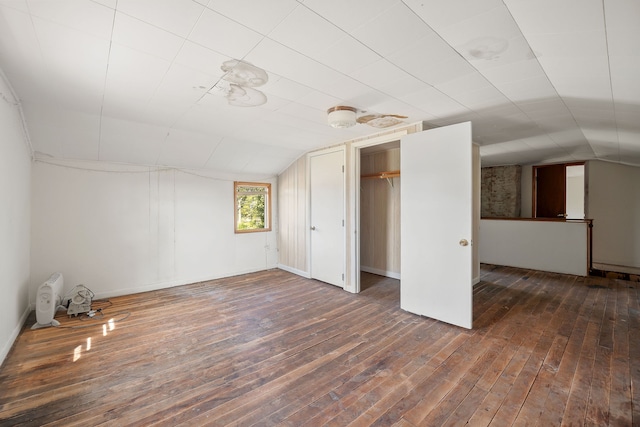 bonus room with dark wood-type flooring and vaulted ceiling