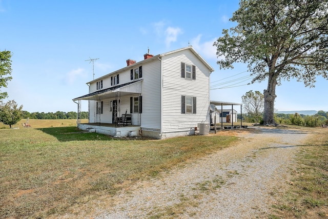 view of property exterior with cooling unit, a yard, and covered porch