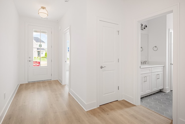 entryway with sink and light hardwood / wood-style floors