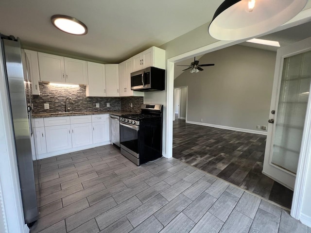 kitchen featuring white cabinets, a ceiling fan, decorative backsplash, stainless steel appliances, and a sink