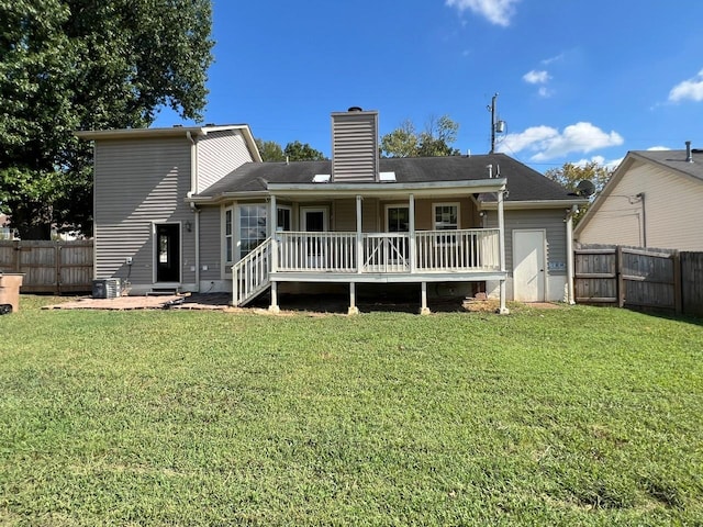 rear view of property with central AC, a fenced backyard, a lawn, and a chimney