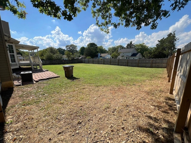 view of yard with central air condition unit, a fenced backyard, and a patio