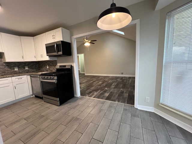 kitchen with tasteful backsplash, white cabinets, a ceiling fan, appliances with stainless steel finishes, and wood finished floors