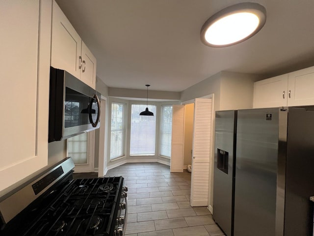 kitchen with stainless steel appliances, decorative light fixtures, and white cabinets