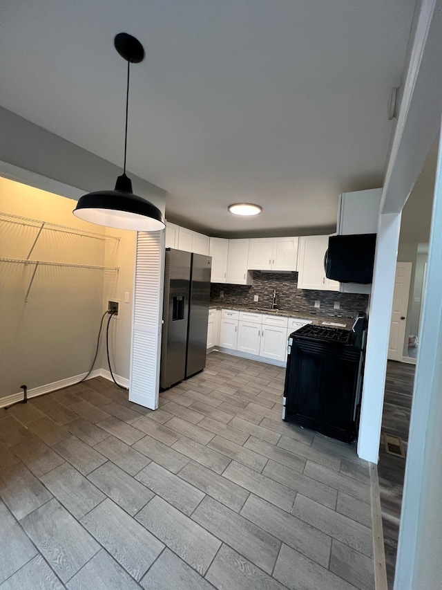 kitchen with black range with gas cooktop, tasteful backsplash, white cabinets, stainless steel fridge with ice dispenser, and wood finish floors