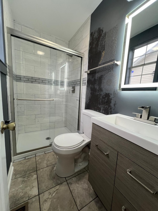 full bathroom with vanity, a shower stall, and toilet