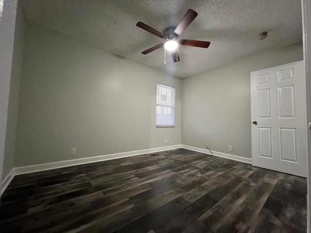 spare room featuring a textured ceiling, ceiling fan, dark wood finished floors, and baseboards