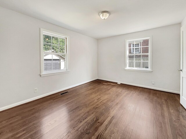 empty room with dark hardwood / wood-style flooring