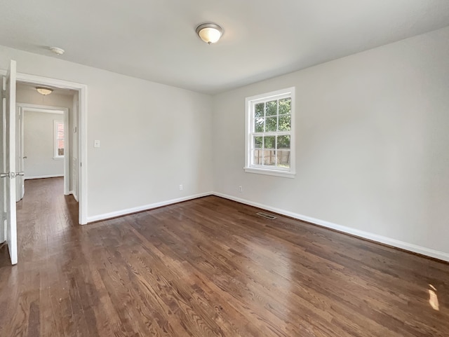 empty room with dark hardwood / wood-style flooring