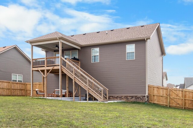 rear view of house featuring ceiling fan, a deck, a lawn, and a patio