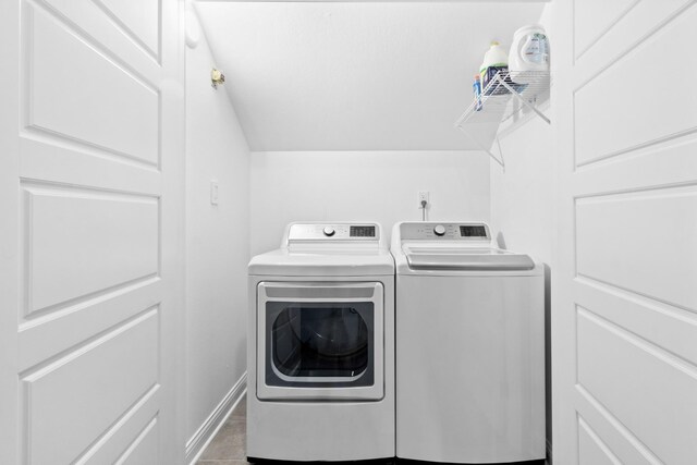 laundry room with washer and clothes dryer and light tile patterned floors