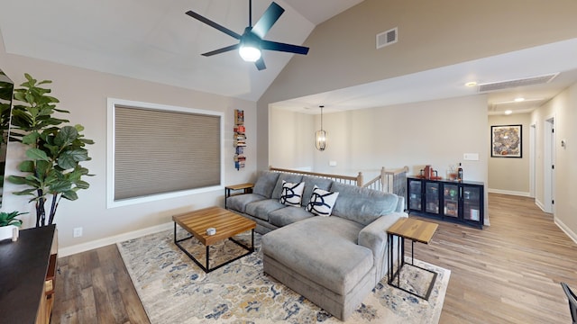 living room with ceiling fan, light hardwood / wood-style flooring, and high vaulted ceiling