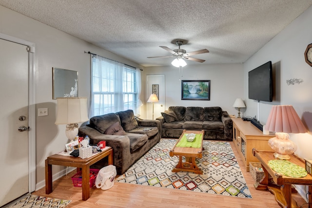 living room featuring a textured ceiling, ceiling fan, and hardwood / wood-style flooring