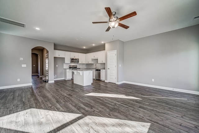 unfurnished living room featuring ceiling fan, dark hardwood / wood-style floors, and sink