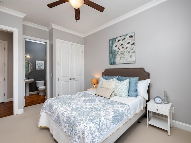 bedroom featuring ceiling fan, ornamental molding, ensuite bathroom, and a closet