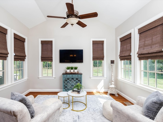 living room with light wood-type flooring, vaulted ceiling, and plenty of natural light