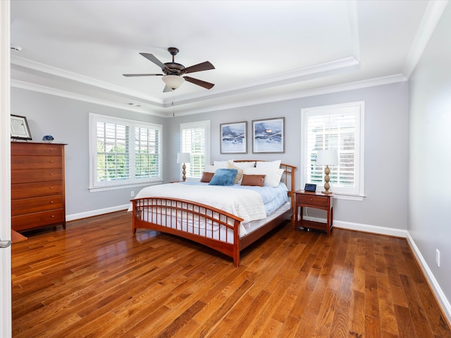 bedroom featuring wood-type flooring, multiple windows, ornamental molding, and ceiling fan