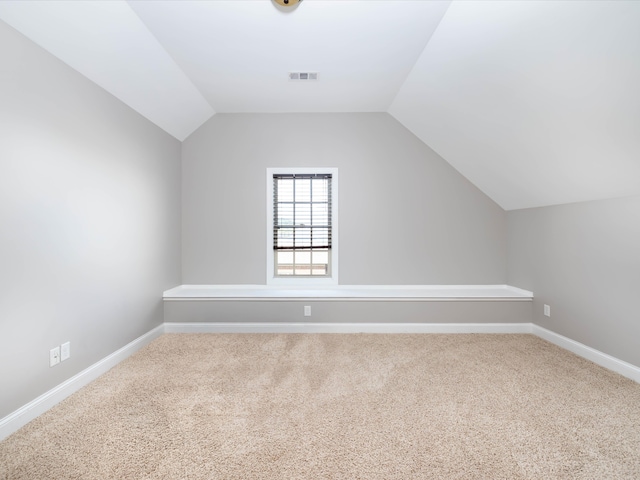 bonus room with carpet floors and vaulted ceiling