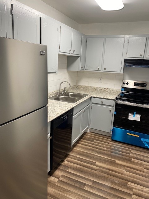 kitchen featuring dark wood-type flooring, stainless steel appliances, sink, and decorative backsplash