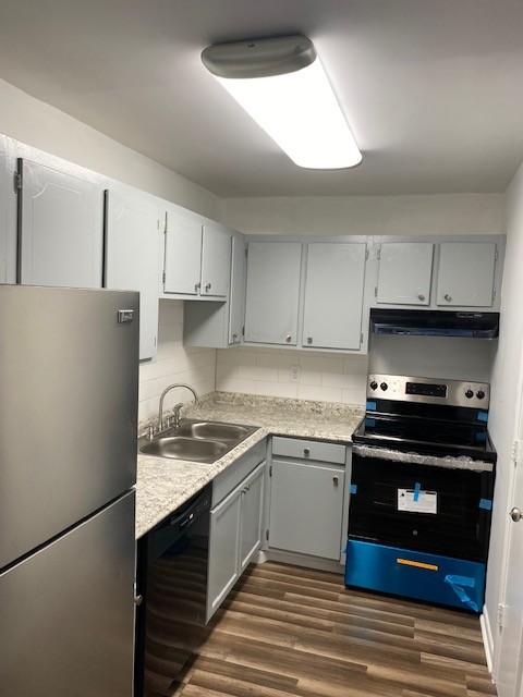 kitchen featuring stainless steel appliances, sink, dark hardwood / wood-style floors, and backsplash