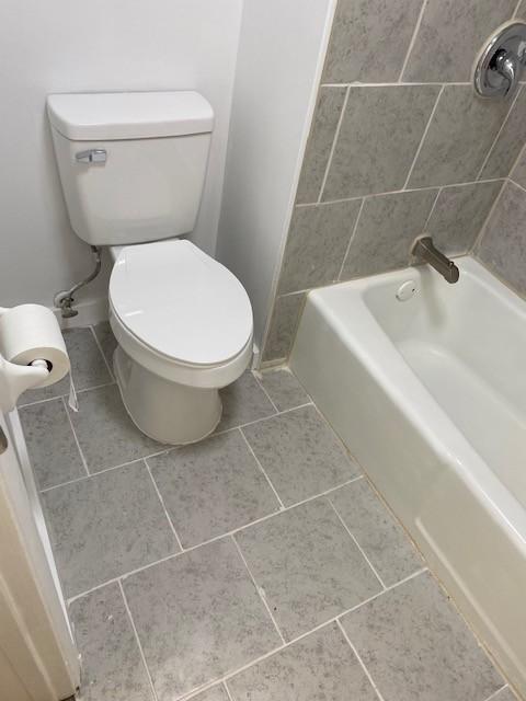 bathroom featuring bathtub / shower combination and toilet