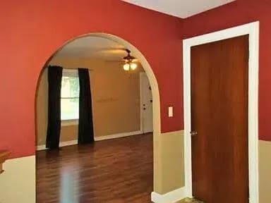 empty room with dark wood-type flooring and ceiling fan