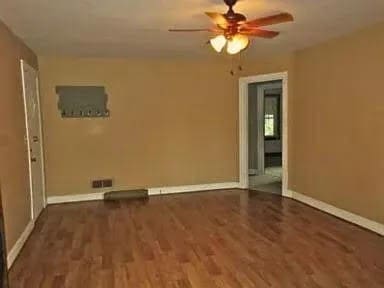 empty room featuring ceiling fan and dark hardwood / wood-style floors