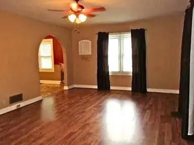 empty room with ceiling fan and dark hardwood / wood-style flooring