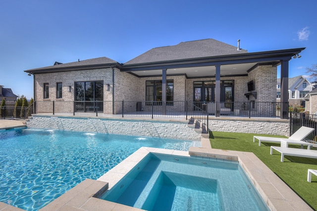 view of swimming pool featuring pool water feature, a patio area, and an in ground hot tub