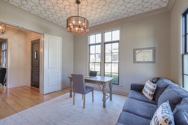 office featuring crown molding, a notable chandelier, and light hardwood / wood-style floors