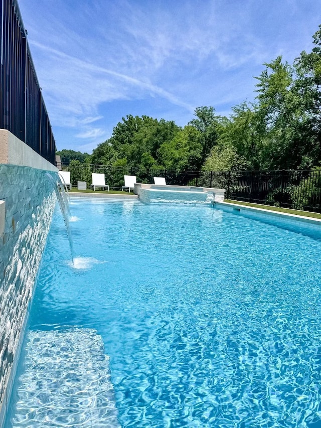 view of swimming pool with pool water feature