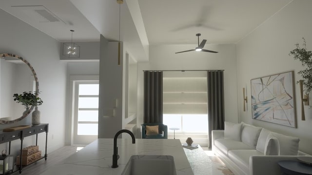 living room with crown molding, ceiling fan, and sink