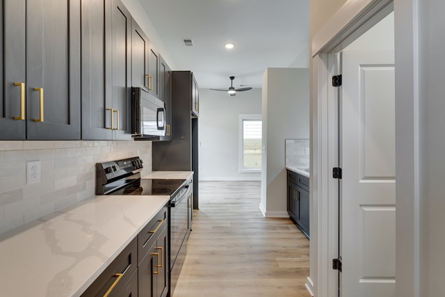 kitchen with light hardwood / wood-style flooring, appliances with stainless steel finishes, light stone counters, ceiling fan, and decorative backsplash