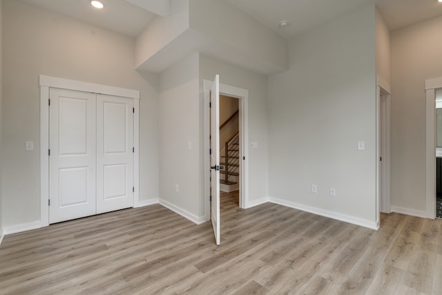 unfurnished bedroom with a closet and light hardwood / wood-style flooring