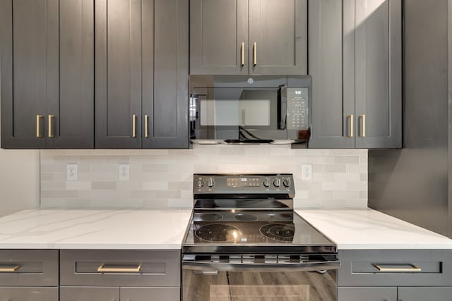 kitchen with gray cabinets, wood-type flooring, light stone counters, and electric stove