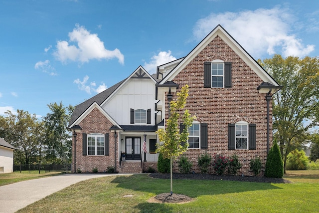 traditional-style home with brick siding, board and batten siding, and a front yard