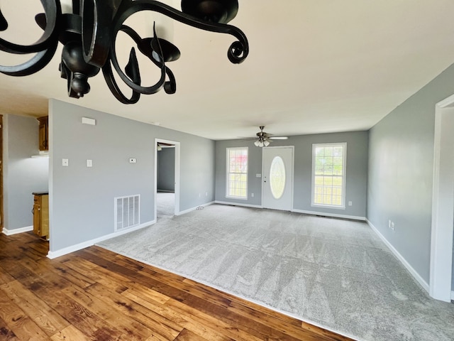 unfurnished living room with ceiling fan and wood-type flooring