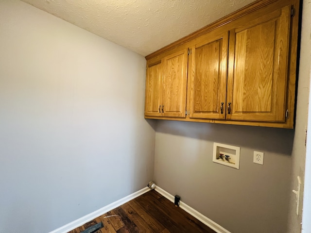 washroom featuring dark hardwood / wood-style floors, cabinets, hookup for a gas dryer, washer hookup, and a textured ceiling