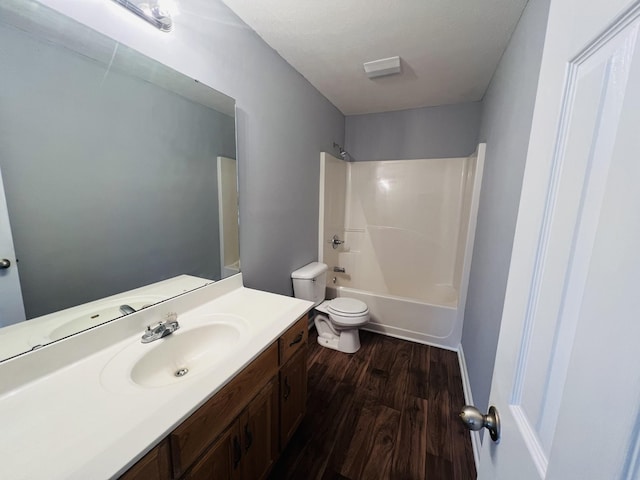 full bathroom with shower / bathing tub combination, vanity, hardwood / wood-style flooring, and toilet