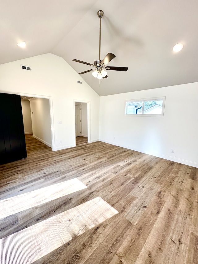 unfurnished living room featuring ceiling fan, light wood-type flooring, and vaulted ceiling