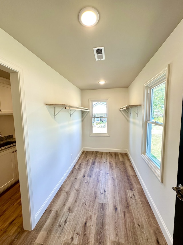 walk in closet featuring light hardwood / wood-style flooring