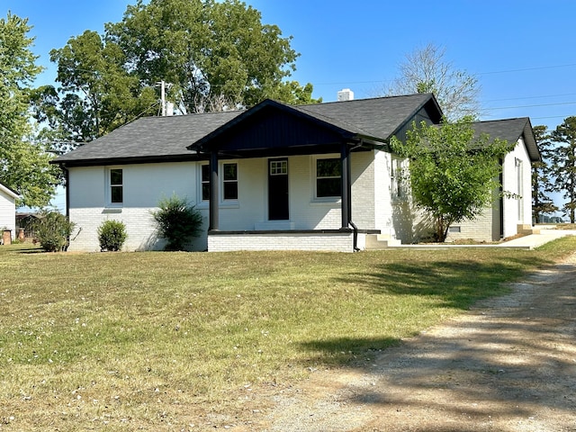 view of front of property featuring a front lawn, covered porch, and a garage