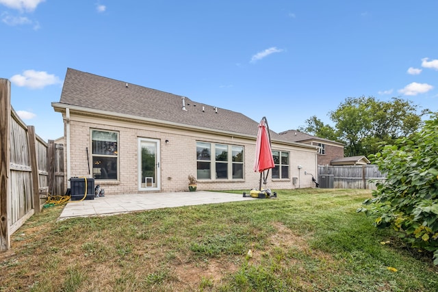 back of property featuring a lawn, a patio, and central AC unit