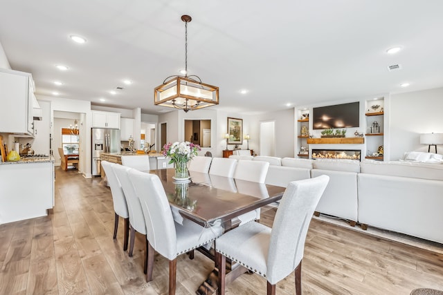 dining space featuring light hardwood / wood-style floors and an inviting chandelier