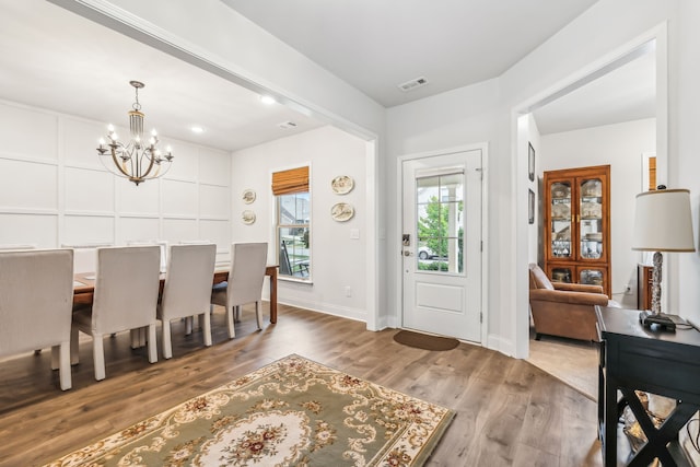 dining area with wood-type flooring and a chandelier