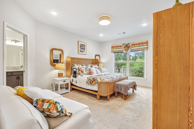 bedroom featuring connected bathroom and carpet flooring