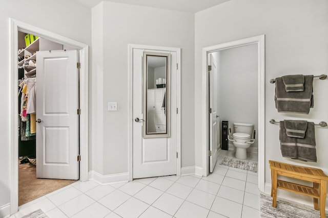 interior space featuring tile patterned flooring and toilet